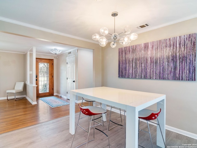 dining area with a chandelier, visible vents, crown molding, and light wood-type flooring