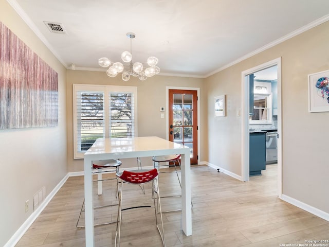 dining room with visible vents, crown molding, and light wood-type flooring