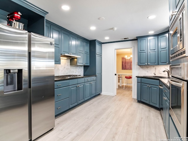 kitchen featuring blue cabinets, visible vents, a sink, appliances with stainless steel finishes, and light wood finished floors