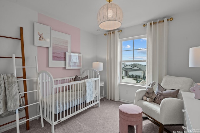 bedroom with a crib, carpet, and baseboards