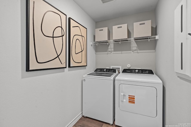 laundry room with dark wood-style floors, visible vents, separate washer and dryer, laundry area, and baseboards