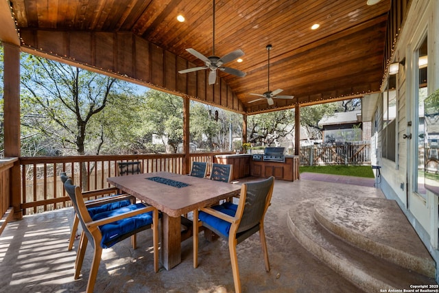 view of patio / terrace featuring an outdoor kitchen, ceiling fan, a grill, fence, and outdoor dining area