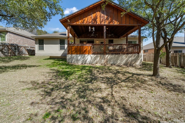 back of property with ceiling fan, a yard, and a fenced backyard