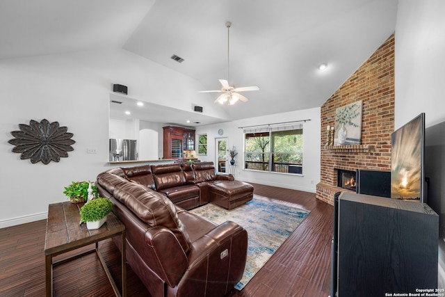 living room featuring high vaulted ceiling, wood finished floors, visible vents, baseboards, and a brick fireplace