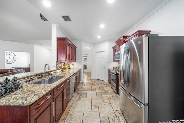 kitchen with stone tile floors, visible vents, appliances with stainless steel finishes, dark brown cabinets, and a sink