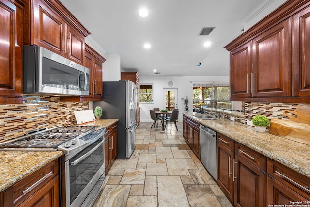 kitchen featuring light stone counters, stone tile floors, a sink, visible vents, and appliances with stainless steel finishes