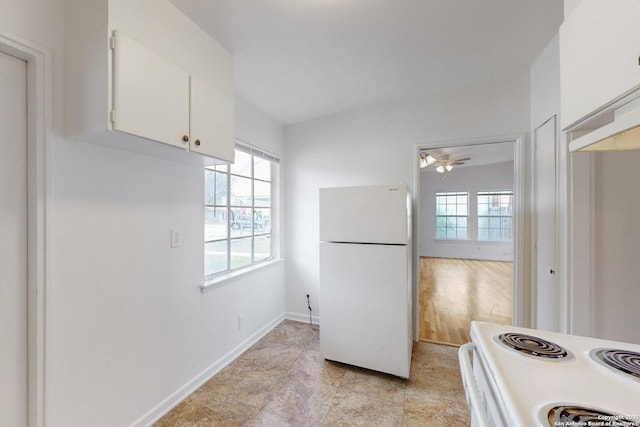 kitchen with white appliances, baseboards, and white cabinets