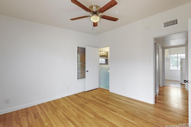 empty room with ceiling fan, baseboards, visible vents, and light wood-style floors