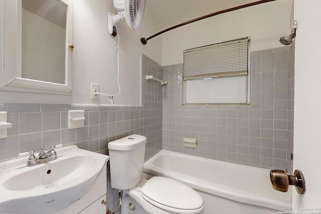 full bath featuring toilet, vanity, tile walls, shower / bathing tub combination, and wainscoting