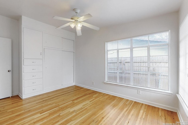 unfurnished bedroom with baseboards, a closet, a ceiling fan, and light wood-style floors