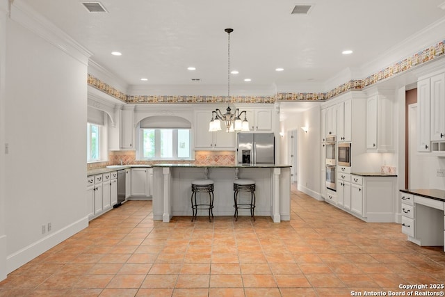 kitchen featuring tasteful backsplash, appliances with stainless steel finishes, visible vents, and a center island