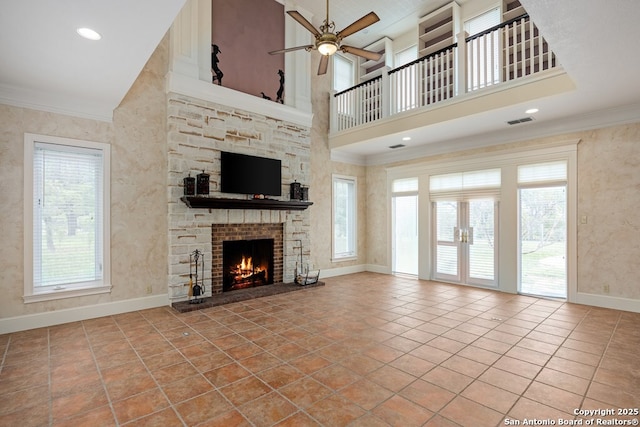 unfurnished living room with visible vents, crown molding, a stone fireplace, and tile patterned floors