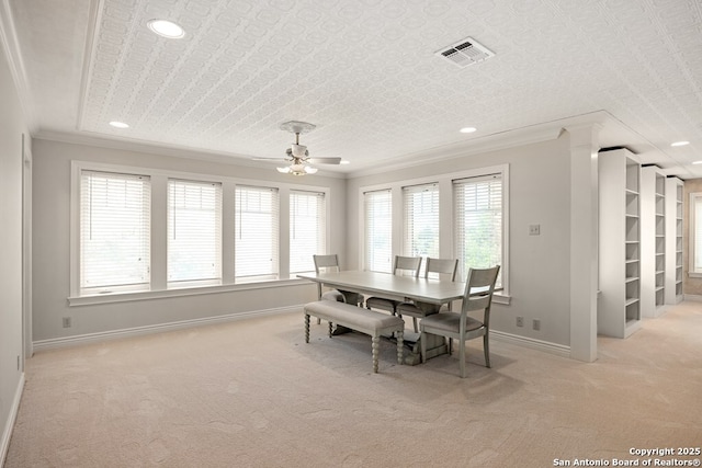 dining area with baseboards, light colored carpet, visible vents, and crown molding