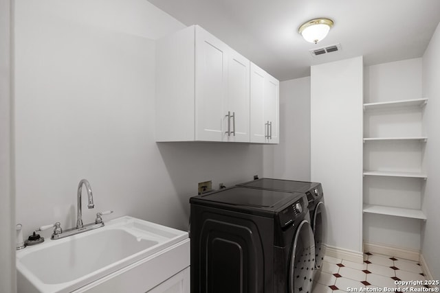 laundry room with light floors, cabinet space, visible vents, a sink, and independent washer and dryer