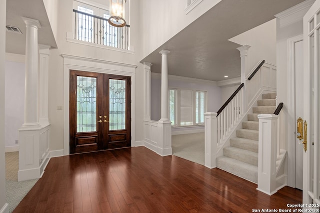 entryway featuring french doors, decorative columns, wood-type flooring, visible vents, and ornamental molding