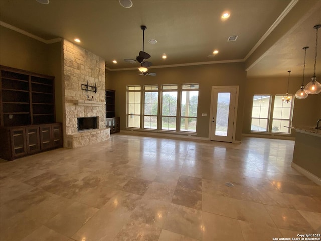 unfurnished living room featuring recessed lighting, ceiling fan with notable chandelier, a fireplace, baseboards, and ornamental molding