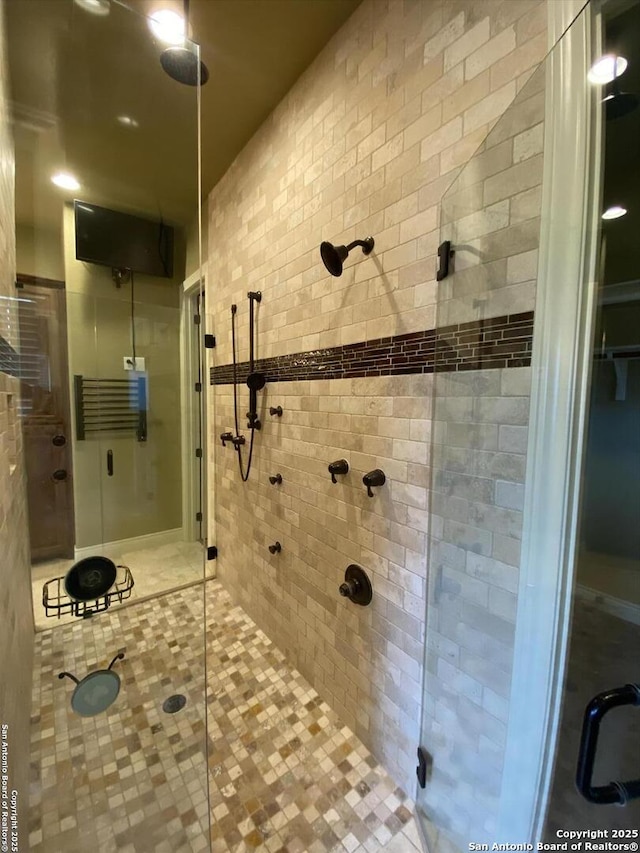 bathroom with a stall shower and tile patterned floors