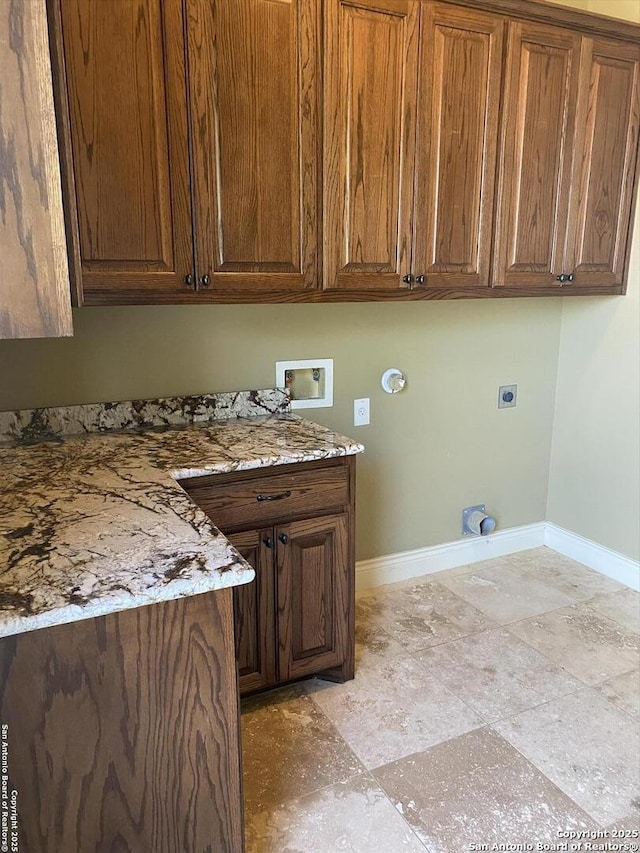 washroom with hookup for a washing machine, cabinet space, electric dryer hookup, and baseboards