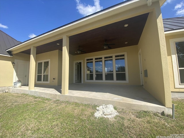 back of property featuring metal roof, a patio, a ceiling fan, stucco siding, and a standing seam roof