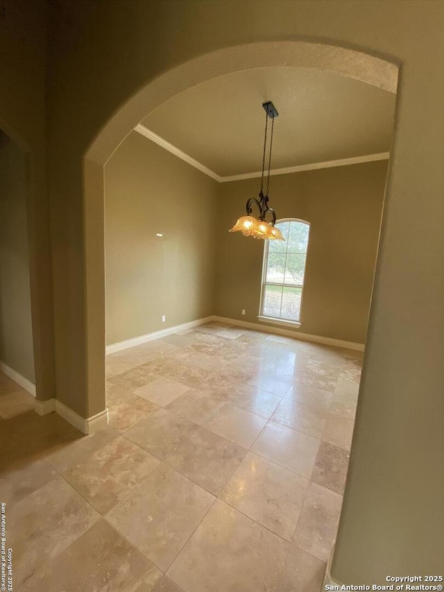 spare room with baseboards, arched walkways, a notable chandelier, and ornamental molding