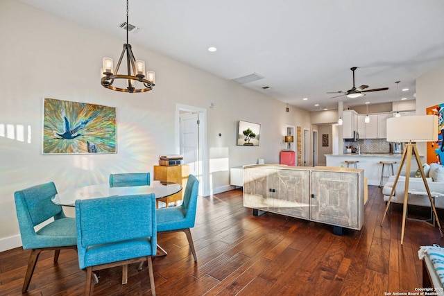 dining space with visible vents, ceiling fan with notable chandelier, dark wood-style floors, recessed lighting, and baseboards