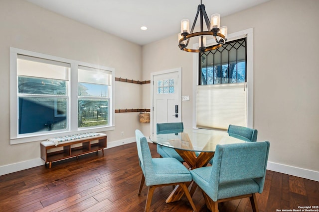 dining space with baseboards, a notable chandelier, and hardwood / wood-style flooring