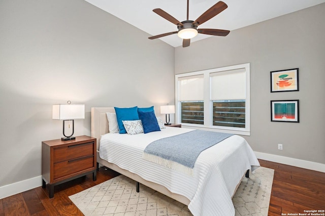 bedroom with baseboards, wood finished floors, and vaulted ceiling