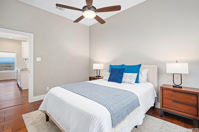 bedroom featuring a ceiling fan, hardwood / wood-style flooring, baseboards, and visible vents