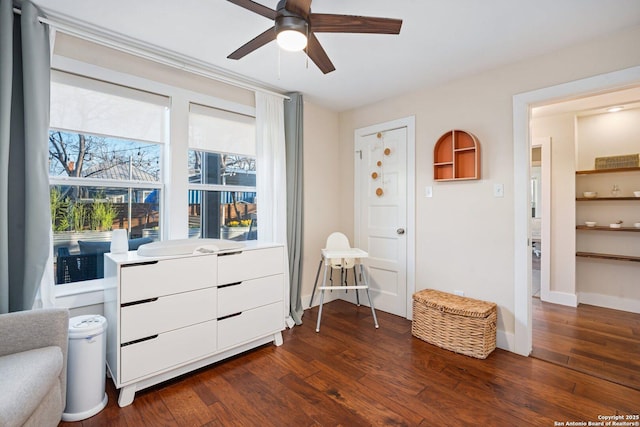 sitting room featuring dark wood-type flooring, a ceiling fan, and baseboards