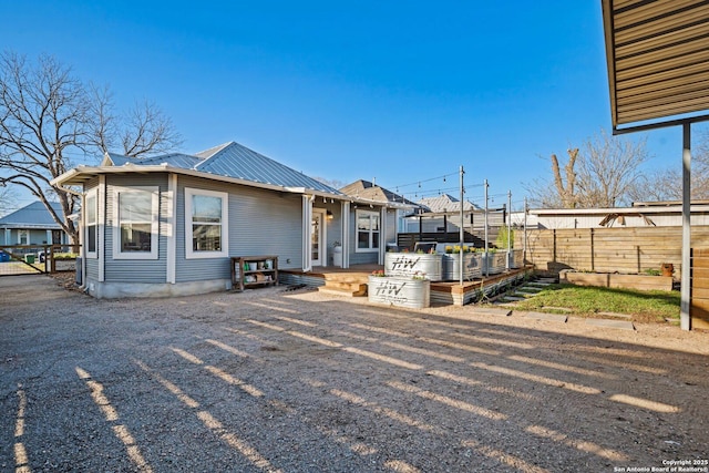 exterior space with fence and metal roof