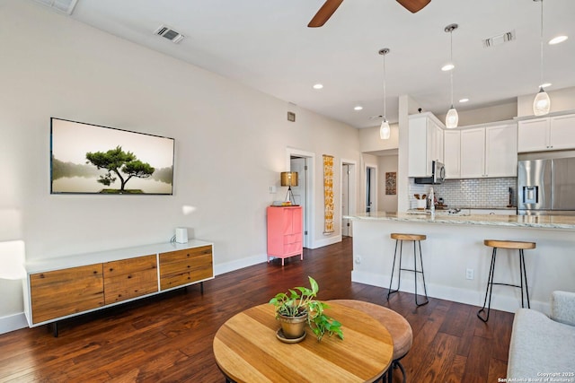 living room with recessed lighting, visible vents, baseboards, and dark wood-style floors