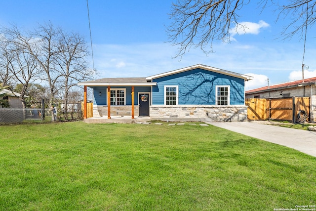 view of front of home with stone siding, a gate, fence, and a front lawn