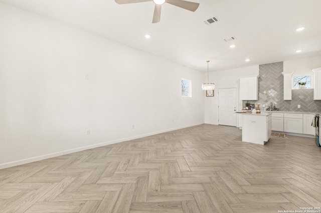 interior space with visible vents, plenty of natural light, baseboards, and ceiling fan