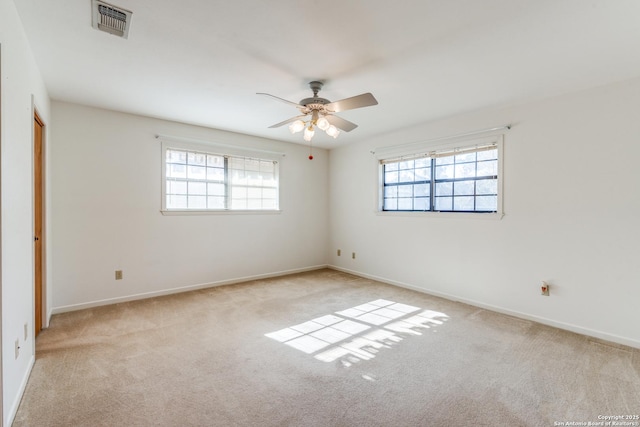 unfurnished room with carpet floors, a wealth of natural light, visible vents, and baseboards