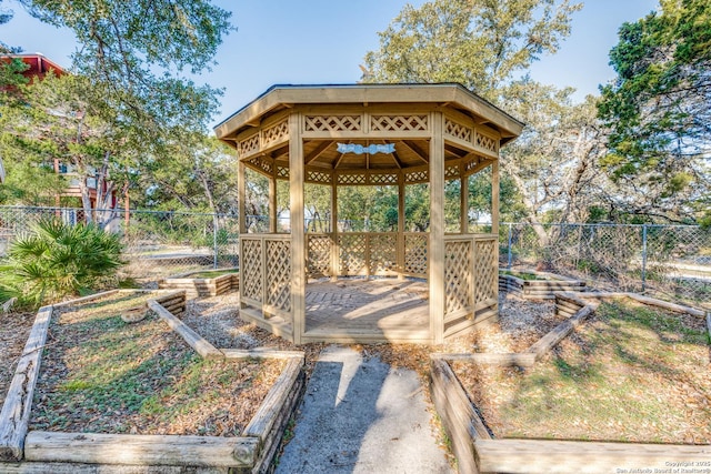 view of community with a garden, a fenced backyard, and a gazebo