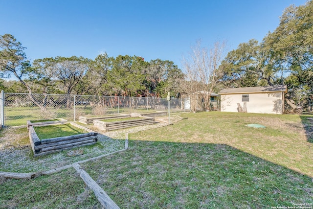 view of yard featuring an outbuilding, a vegetable garden, and fence