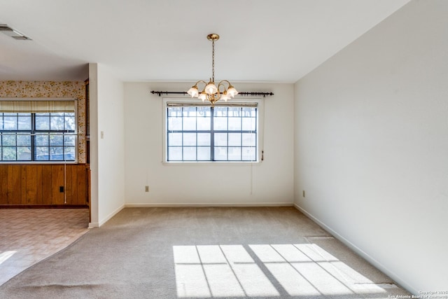 unfurnished dining area featuring light carpet, an inviting chandelier, visible vents, and a healthy amount of sunlight