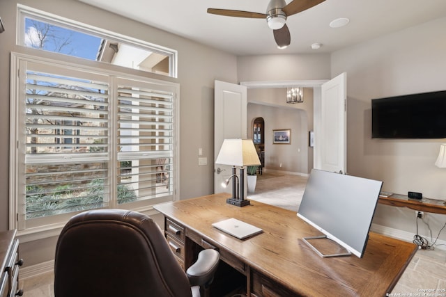 office area with baseboards, a ceiling fan, and a healthy amount of sunlight