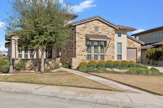 view of front of home featuring stone siding, a front lawn, and an attached garage