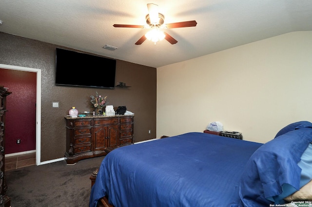 bedroom featuring a ceiling fan, visible vents, vaulted ceiling, and carpet flooring