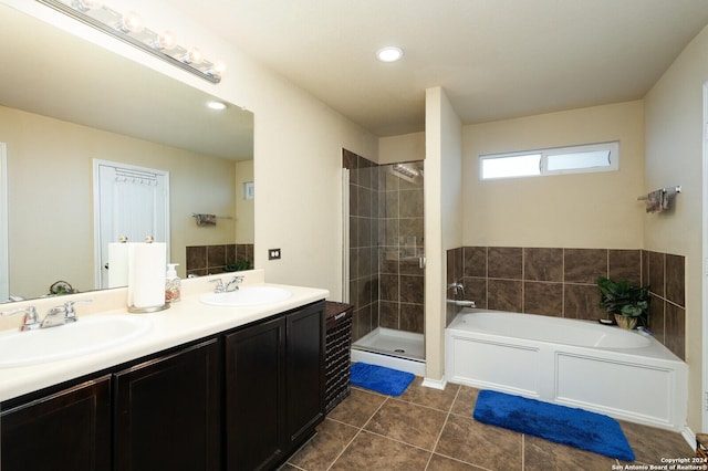 bathroom featuring double vanity, a stall shower, a garden tub, and a sink