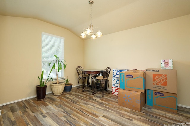 dining space with an inviting chandelier, baseboards, vaulted ceiling, and wood finished floors