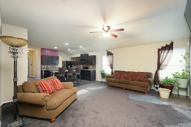 carpeted living room featuring lofted ceiling, ceiling fan, a textured ceiling, and a wealth of natural light