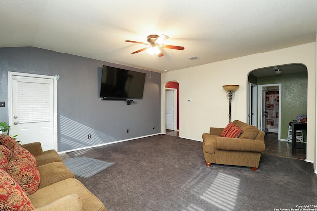 carpeted living area with visible vents, arched walkways, baseboards, ceiling fan, and vaulted ceiling