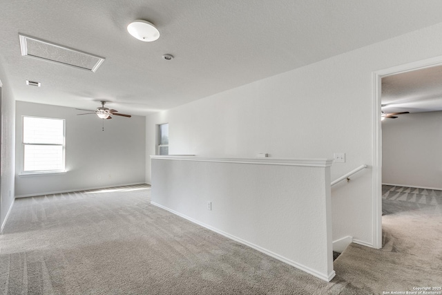 spare room with baseboards, carpet, visible vents, and a textured ceiling