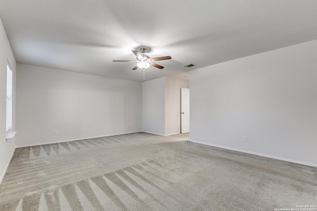 spare room with visible vents, a ceiling fan, light carpet, a textured ceiling, and baseboards