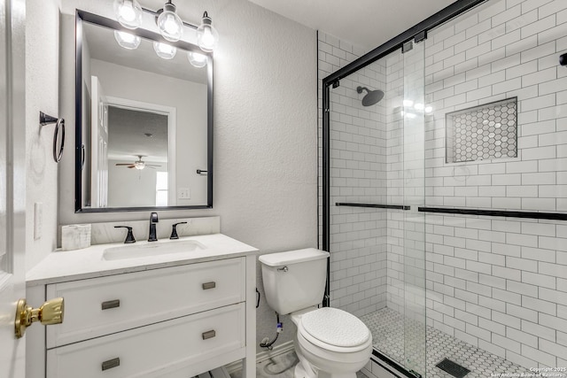 bathroom with a stall shower, a textured wall, vanity, and toilet