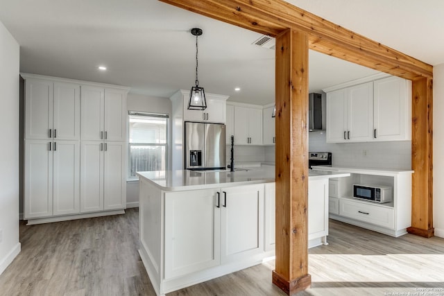 kitchen featuring stainless steel fridge, visible vents, white cabinets, light wood-style flooring, and light countertops