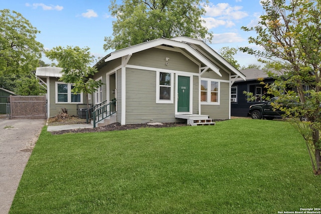 view of front of home featuring a front yard, fence, and a gate