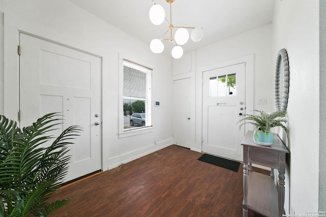 entrance foyer with dark wood-style floors, an inviting chandelier, and baseboards